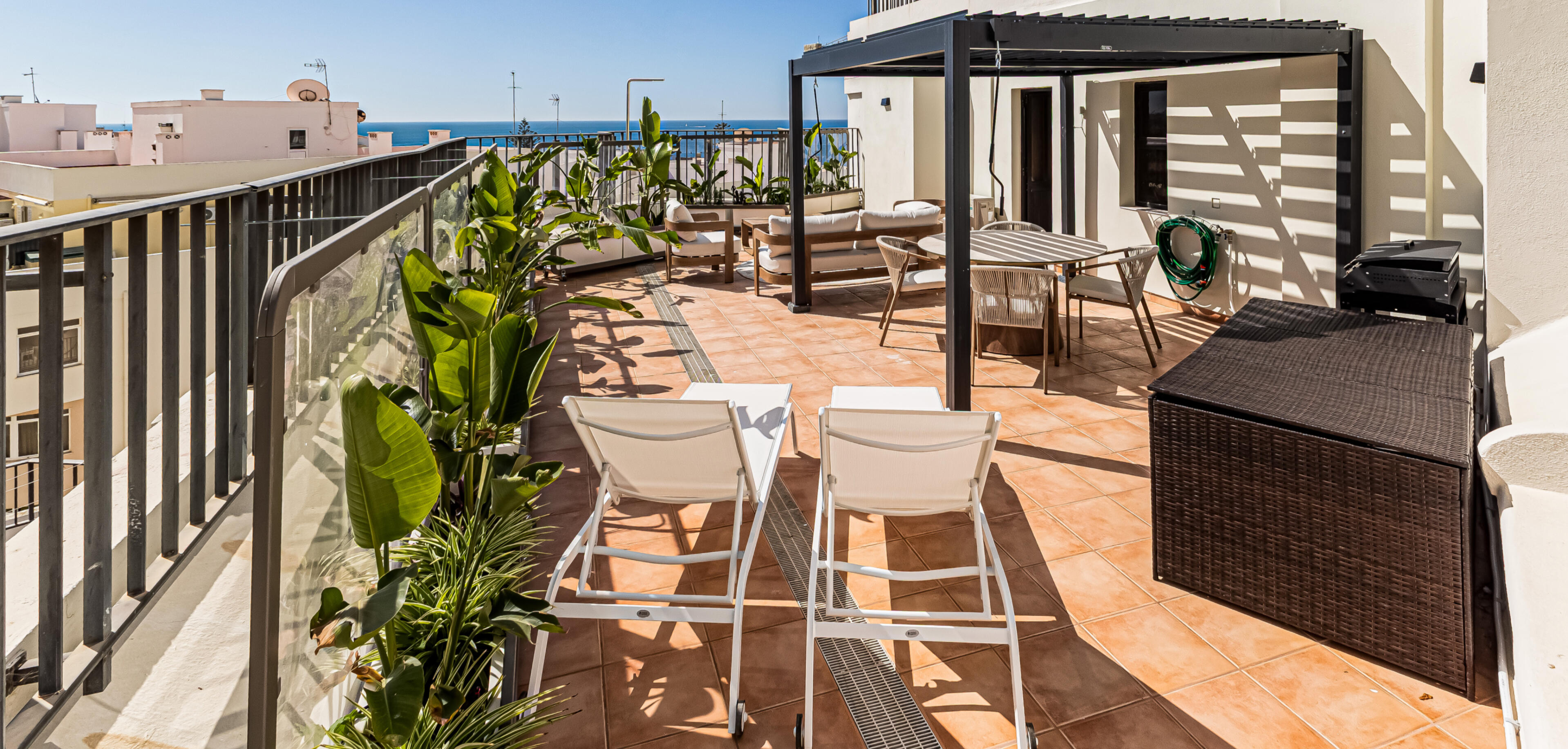 Large private terrace with pergola, lounge, dining area and ocean view in Algarve apartment